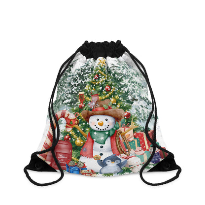 A drawstring backpack with a festive Christmas print featuring a snowman, decorated tree, gifts, and a penguin, with black drawstring cords, shown on a plain white background.