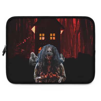 A laptop sleeve featuring a dark, horror-themed graphic print of a creepy zombie-like figure in front of a haunted house and red-lit forest.