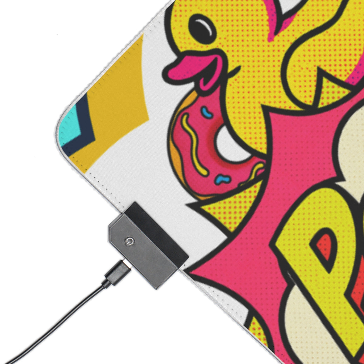 A close-up of a colorful printed surface, likely a mouse pad or desk mat, featuring a cartoon duck eating a pink frosted donut in a bold comic-style design. A black cable is plugged into a small black power bank attached to the bottom edge.