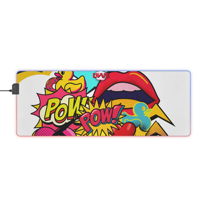 A rectangular gaming mouse pad with a vibrant pop-art comic book design featuring red lips, yellow 'POW! POW!' speech bubbles, and a yellow duck, shown on a white background with a power cable plugged in on the left.