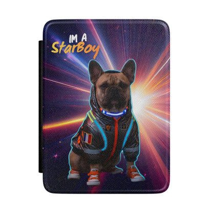 A square tablet case featuring a printed graphic of a French Bulldog wearing a futuristic space-themed jumpsuit with glowing blue and orange accents, set against a cosmic starburst background. The text 'IM A StarBoy' is printed at the top left.