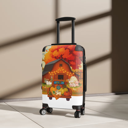 A hard-shell rolling suitcase with an extended telescoping handle stands upright on a light floor against a beige wall. The suitcase has a colorful printed design featuring a barn, pumpkins, autumn leaves, and a horse.