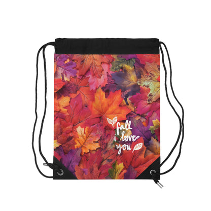 A drawstring backpack featuring a vibrant autumn leaf print with the text 'fall love you' in white script, set against a plain white background.