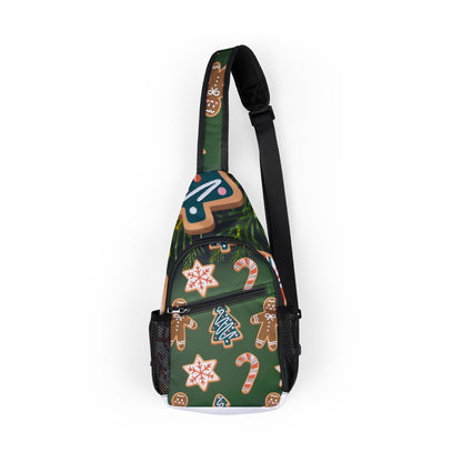 A single-strap sling backpack with a dark green background featuring a festive gingerbread cookie and candy cane pattern, shown on a plain white background.