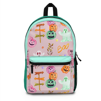A pink backpack with a Halloween-themed print featuring cartoon pumpkins, ghosts, directional signs, and the word 'Boo' in orange, green, white, and yellow. The backpack has mint green piping, a black top handle, and a front zippered pocket.