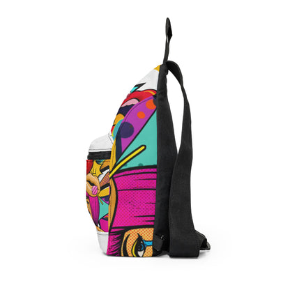 A side-profile view of a sling backpack featuring a vibrant, multicolored pop-art graphic print and a solid black adjustable shoulder strap, set against a plain white background.