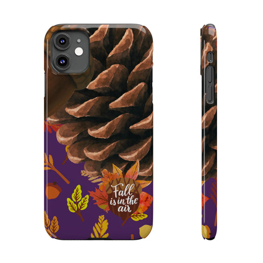 A phone case shown from the back and side on a white background. The case features a large brown pinecone on a dark background with a purple lower section decorated with orange, yellow, and red autumn leaves and the phrase 'Fall is in the air'.