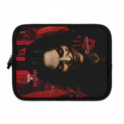 A black zippered laptop sleeve featuring a graphic print of a horror character with pale skin, red eye makeup, and red blood splatters, with text reading 'Queen of Scream' and 'Banshee'.