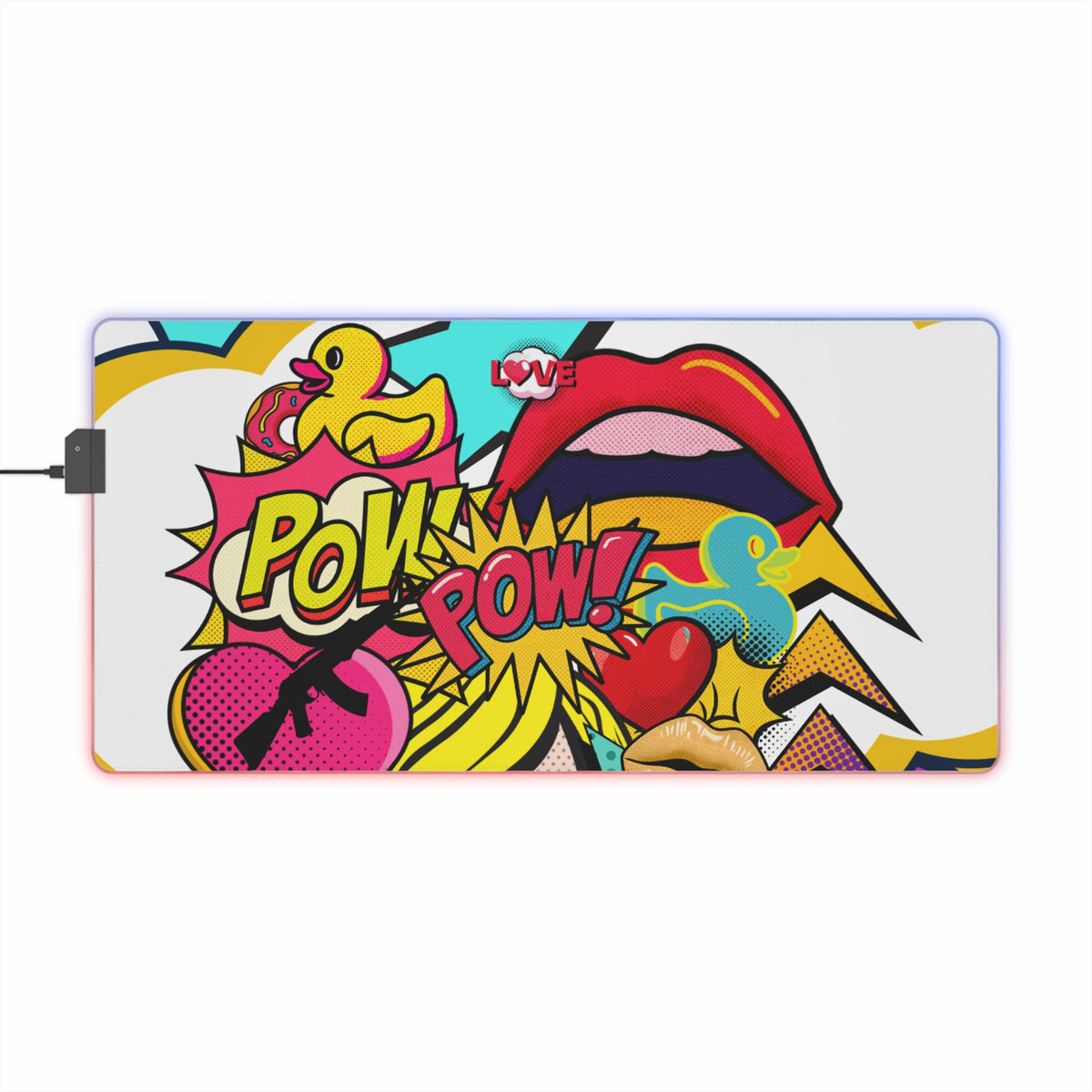 A rectangular desk mat with a vibrant pop-art comic book design featuring a yellow rubber duck, red lips, a pink heart, and 'POW! POW!' text, shown on a plain white background with a power cable extending from the left.