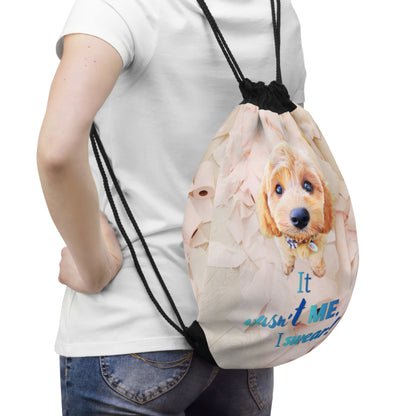 A person wearing a white t-shirt and blue jeans carries a beige drawstring backpack with a printed cartoon dog design and the text 'It visited ME, I remember'.