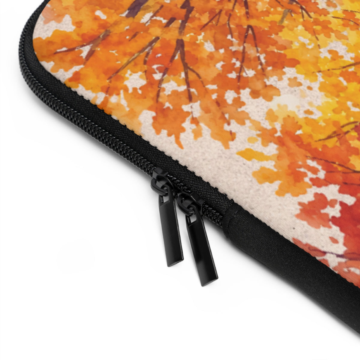 Close-up of a zippered sleeve with a warm autumn leaf print in orange, yellow, and cream, finished with black trim and dual black zipper pulls on a white background.