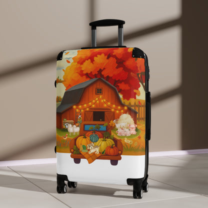 A hard-shell spinner suitcase with a colorful autumn farm illustration, standing upright on a light floor against a beige wall with soft window shadows.