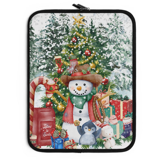 A laptop sleeve featuring a festive Christmas illustration with a snowman, decorated tree, snow, gifts, candy canes, and a red Santa mailer, shown on a plain white background.
