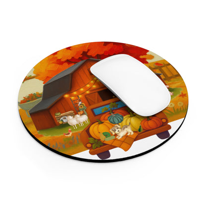 A round mouse pad with a colorful autumn farm illustration, featuring a barn, pumpkins, sheep, and a small dog, shown on a white background with a white computer mouse resting on top.