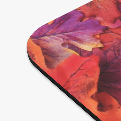 A close-up of a rounded-corner product featuring a printed autumn leaf pattern in vivid orange, red, purple, and yellow tones, shown against a plain white background.