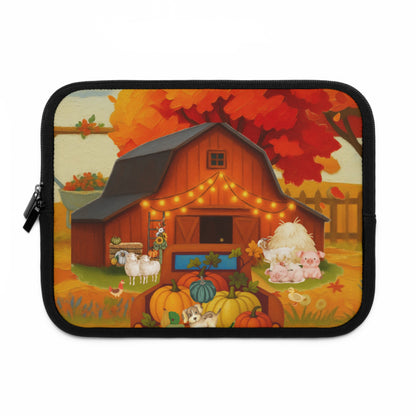 A rectangular laptop sleeve with rounded corners, featuring a colorful autumn farm illustration. The design shows a red barn decorated with string lights, pumpkins, sheep, pigs, and a dog under red and orange autumn trees.