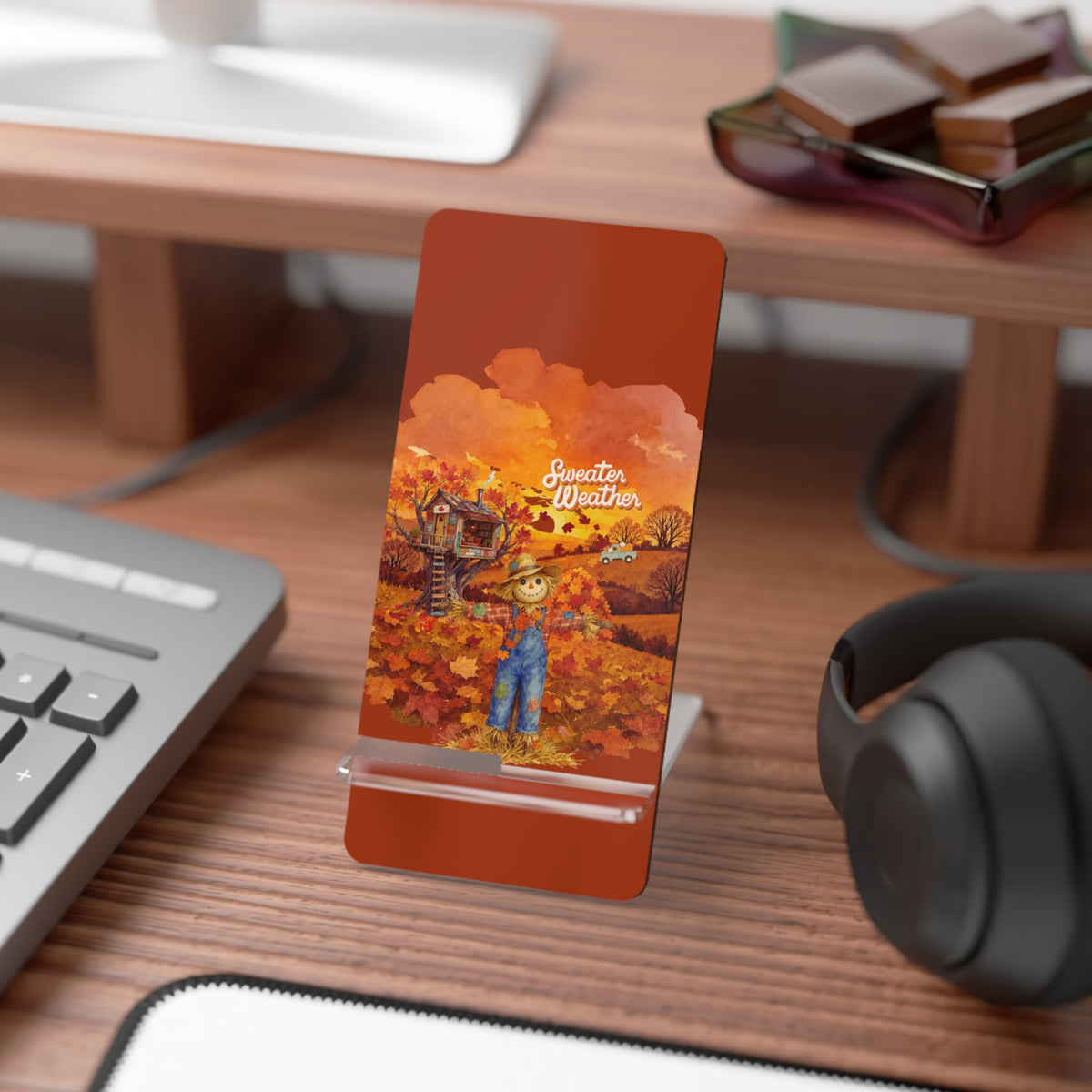 A rectangular PHONE STAND  WITH rounded corners stands on a clear stand on a wooden desk. The card has an autumn illustration with the text 'Summer Dreams' and shows a cartoon character in blue overalls standing in an orange field.