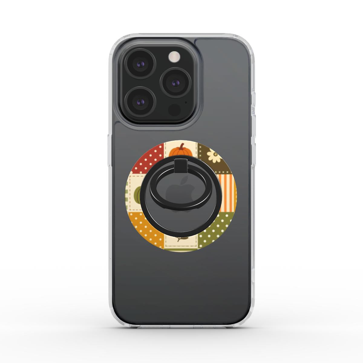 A dark gray phone case with a circular autumn-themed patchwork design featuring a pumpkin and seasonal patterns, centered around a black ring stand.