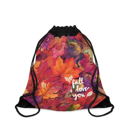 A drawstring gym bag featuring a vibrant autumn leaf print with the phrase 'fall i love you' in white script, set against a plain white background.