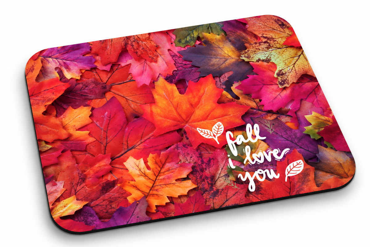 A rectangular mouse pad with rounded corners featuring a vibrant collage of autumn leaves in red, orange, yellow, and purple, with the white script text 'fall love you' printed on the right side.