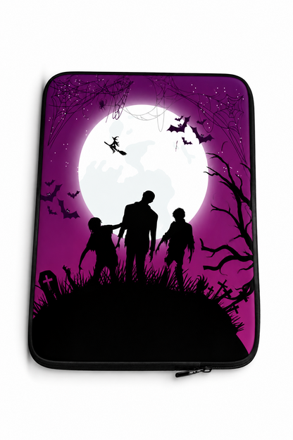 A laptop sleeve featuring a Halloween-themed graphic print with black silhouettes of a family, bats, and spooky tree branches against a purple and magenta background with a large white moon.