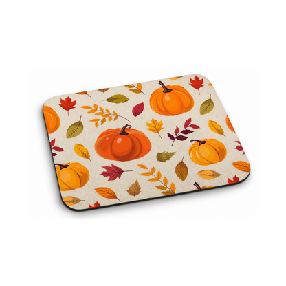 A rectangular mouse pad with rounded corners featuring a fall harvest pattern of orange pumpkins and colorful autumn leaves on a cream background, shown on a white studio background.