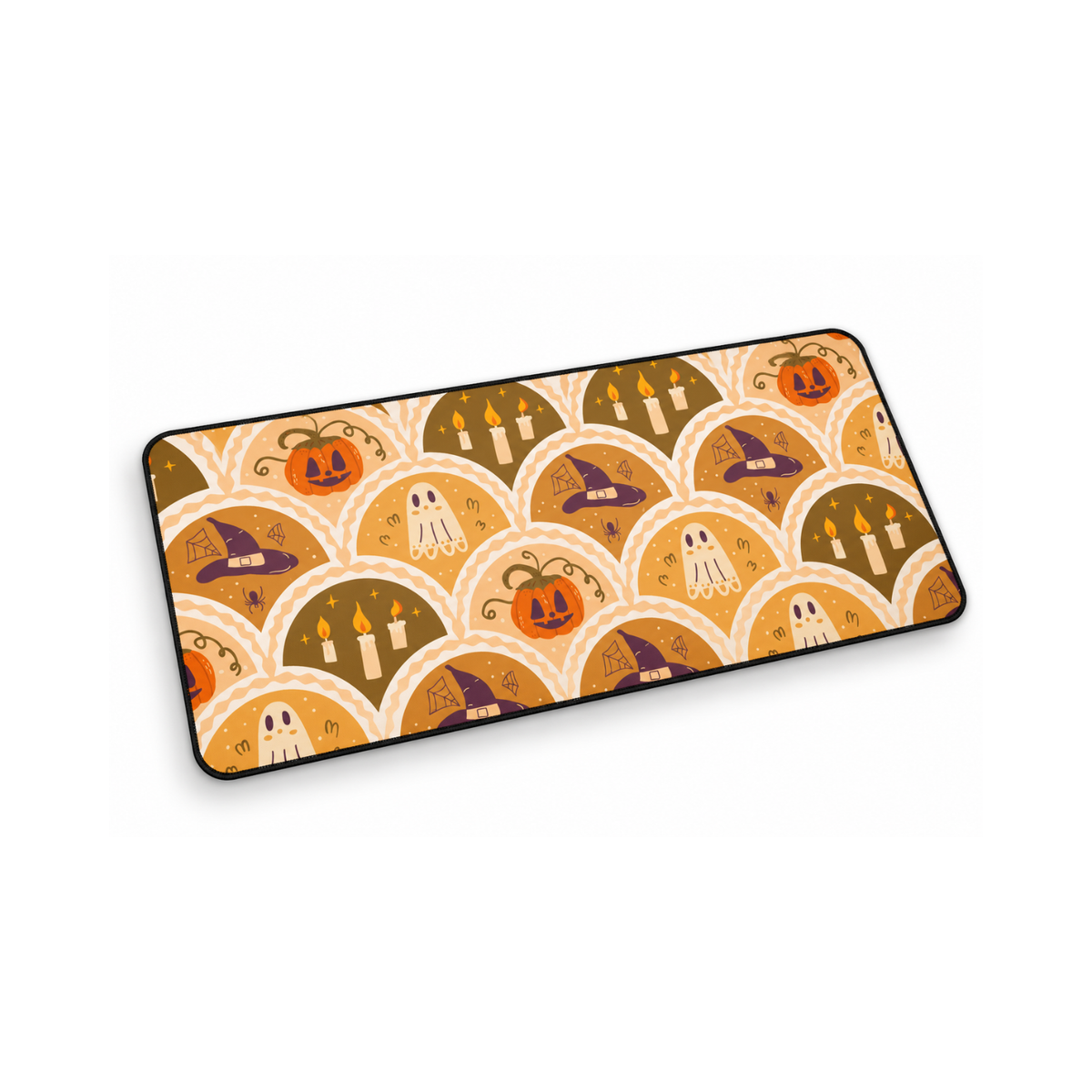 A rectangular DESK MAT with a Halloween-themed pattern featuring pumpkins, ghosts, witch hats, and candles in a repeating scallop design, shown on a plain white background.