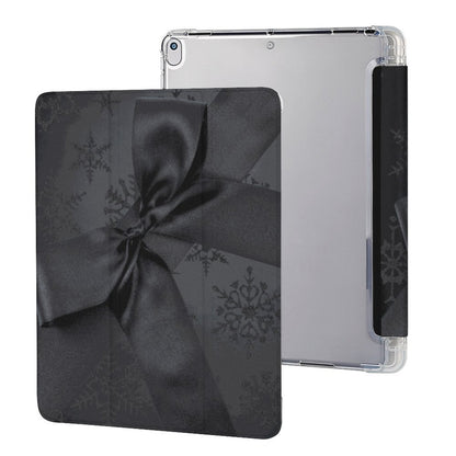 A clear protective case for an iPad, shown from the back and side, featuring a black gift box pattern with a satin ribbon and snowflake design.